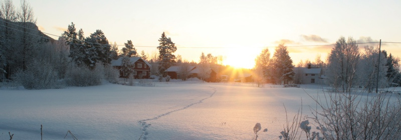 Vinterlandskap med hus och solnedgång